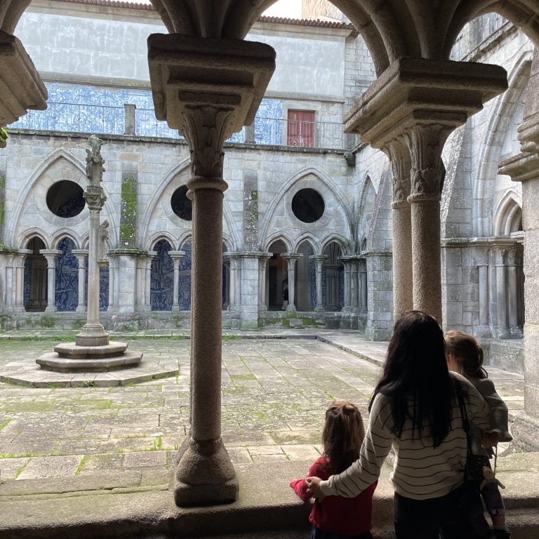 Adult and children looking into a courtyard of Se Cathedral in Portugal