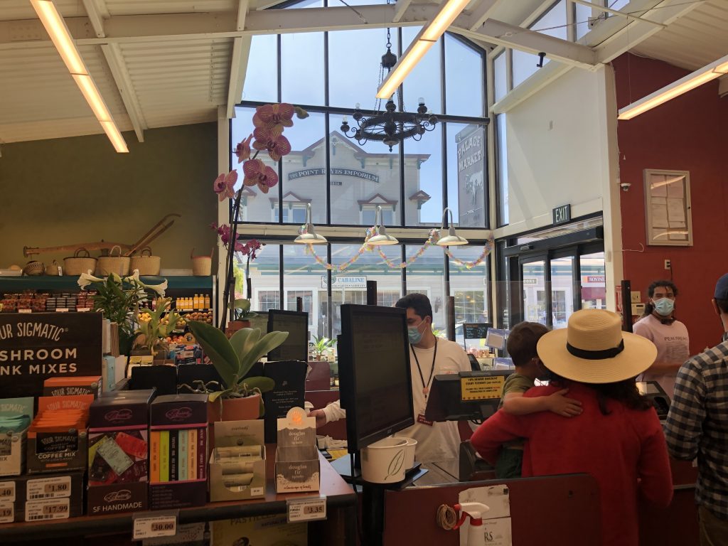 An adult at a cash register at the Point Reyes Station Market